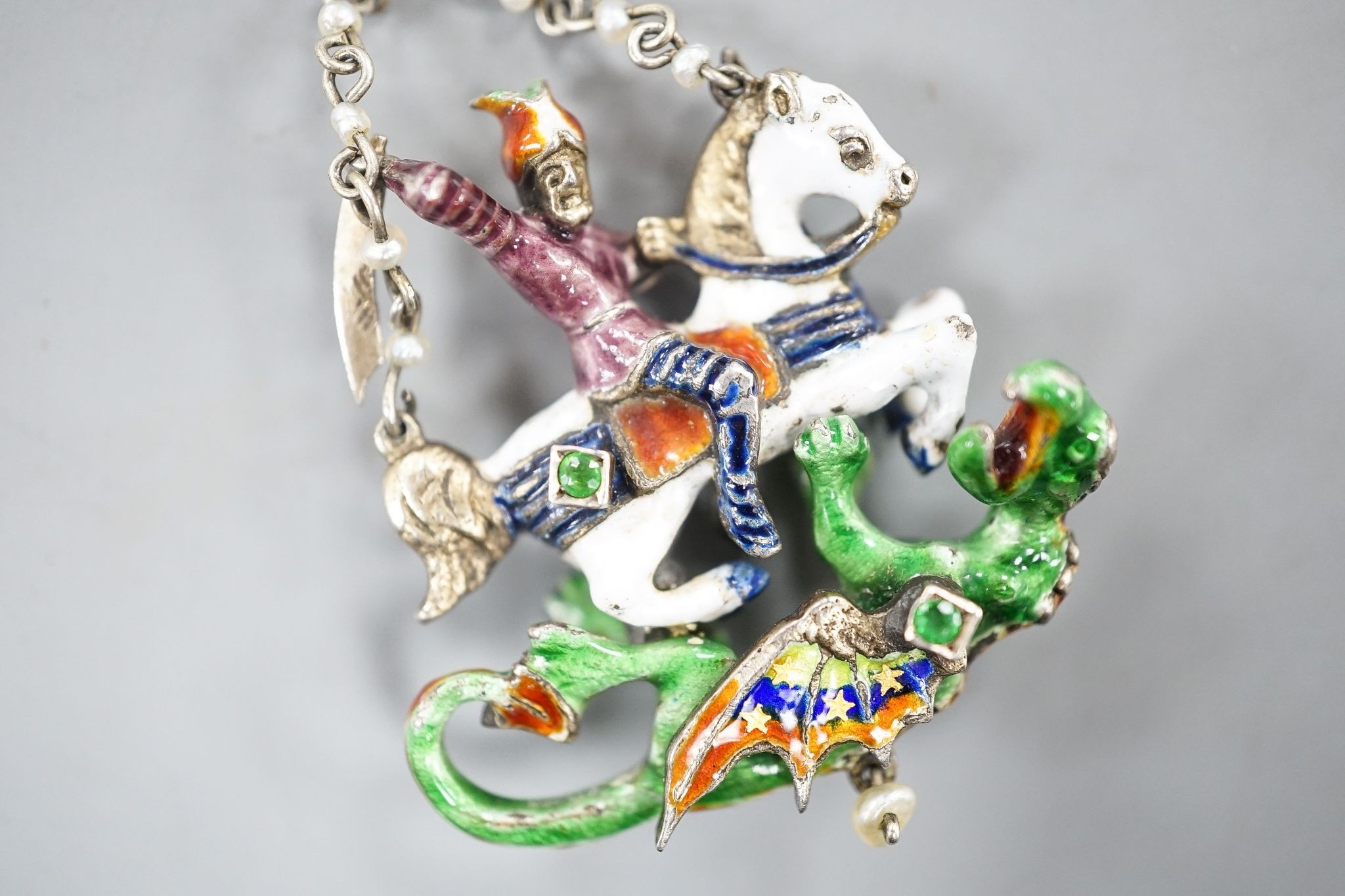A 19th century Austro-Hungarian? gilt white metal, polychrome enamel, seed pearl and gem set 'St George & The Dragon' drop pendant, 4cm.